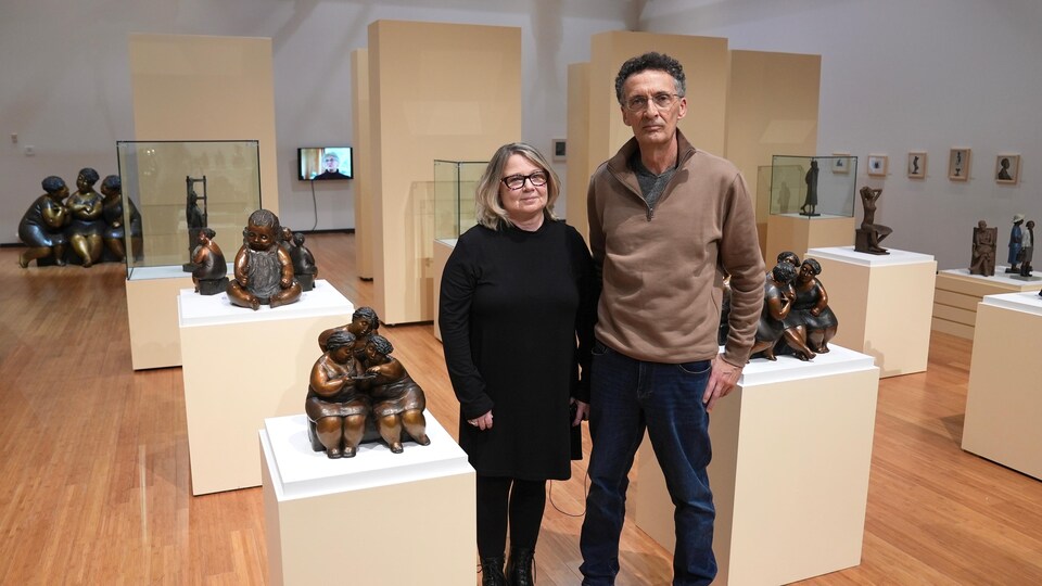 Un homme et une femme devant des sculptures.