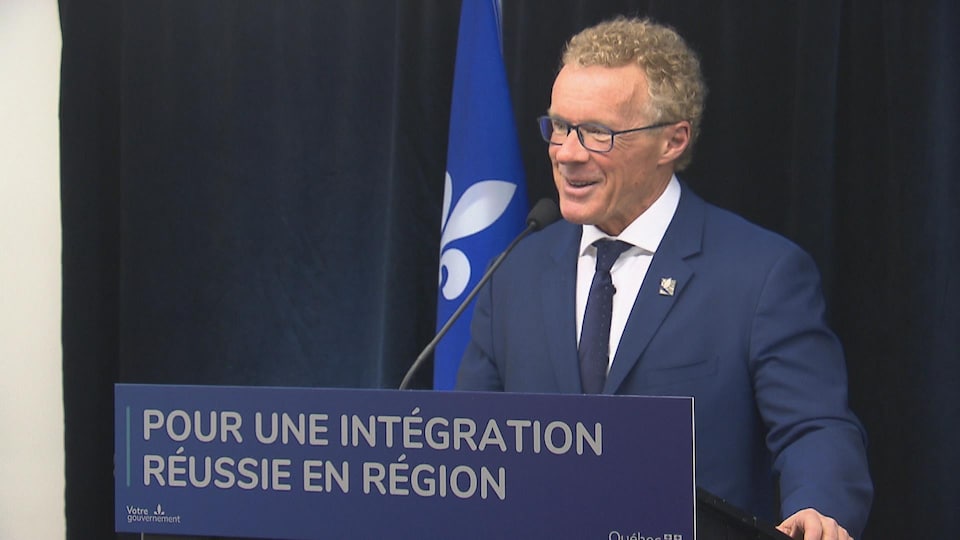 Le ministre Jean Boulet, derrière un micro, répond aux journalistes.