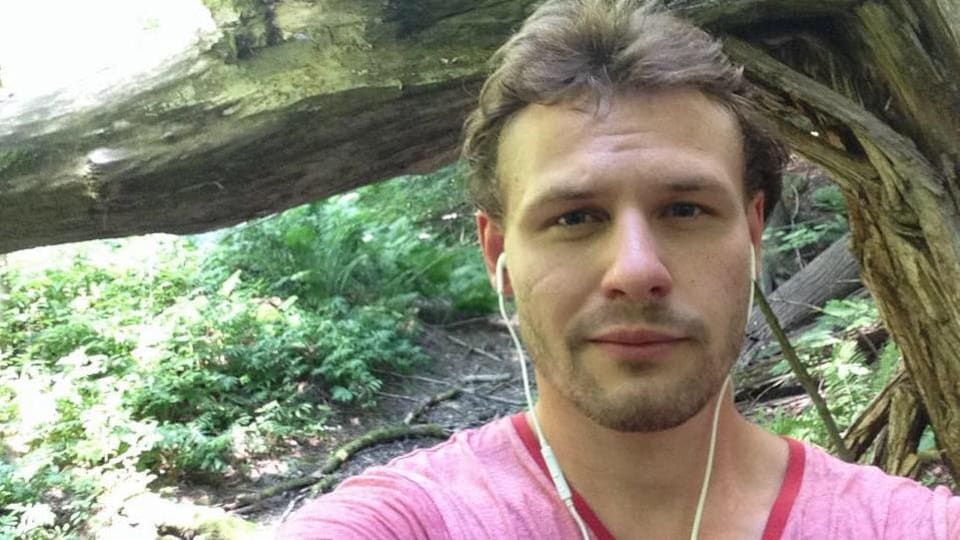 Photo d'un homme dans une forêt avec des écouteurs.