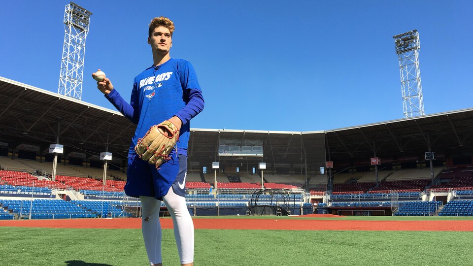 Vêtu d'un chandail des Blue Jays, Jean-Christophe Masson s'apprête à lancer une balle au Stade Canac.