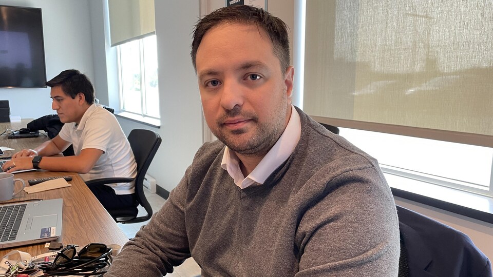 Jean-Félix Lepage, assis à son bureau, posant pour la caméra.