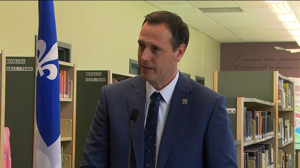 Jean-François Roberge lors d'une conférence de presse dans la bibliothèque d'une école.
