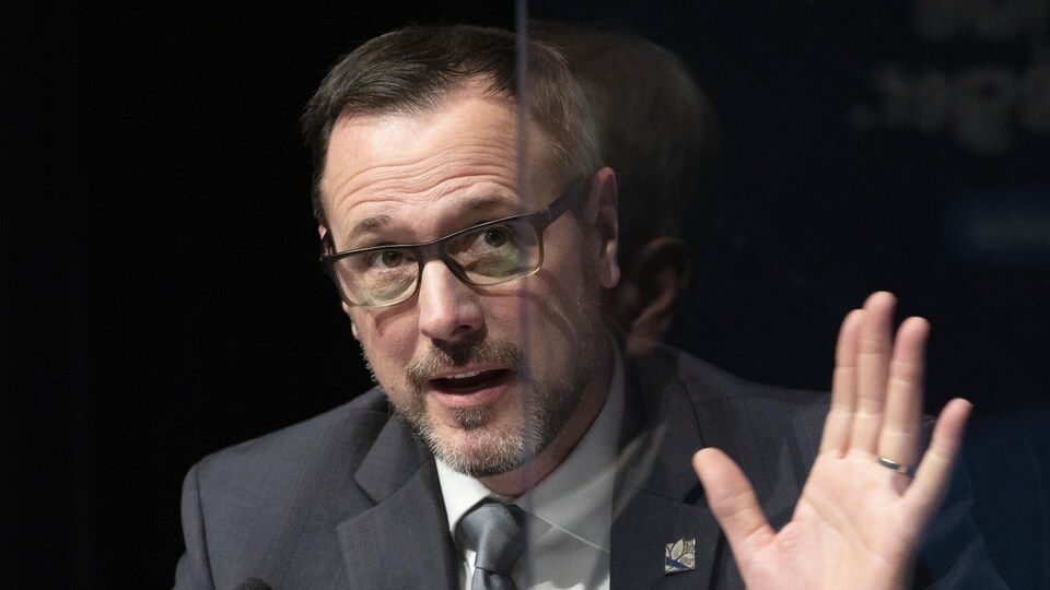 Jean-François Roberge assis à la table de presse. 