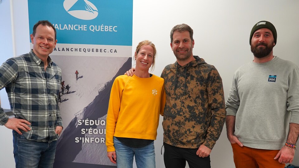 Les quatre sourient debout à côté de la bannière d'Avalanche Québec.