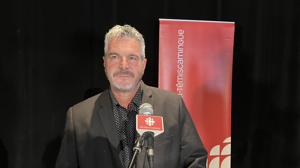 Jean-Maurice Matte près du micro de Radio-Canada lors du débat.
