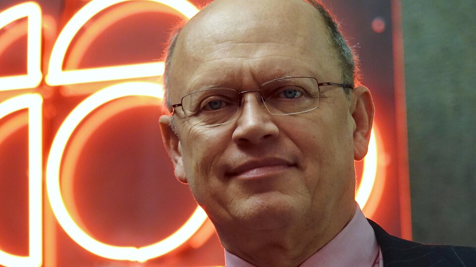 Jean-Pascal van Ypersele devant une enseigne illuminée de Radio-Canada