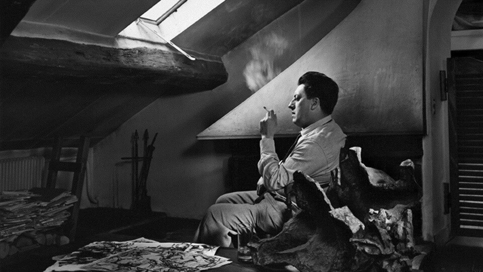 Jean-Paul Riopelle en 1965, qui fume assis dans son atelier de Paris. 
