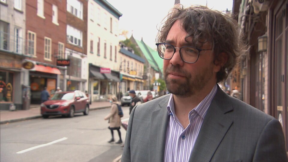 Jean-Pierre Lessard répond aux questions d'un journaliste devant la rue passante à Québec.