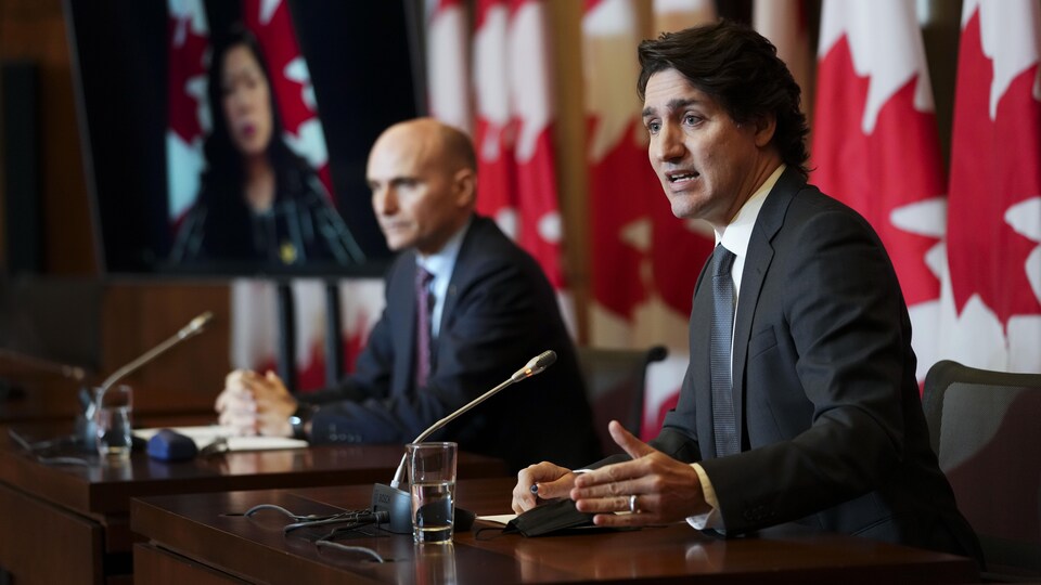 Justin Trudeau et Jean-Yves Duclos assis côte à côte en conférence de presse.
