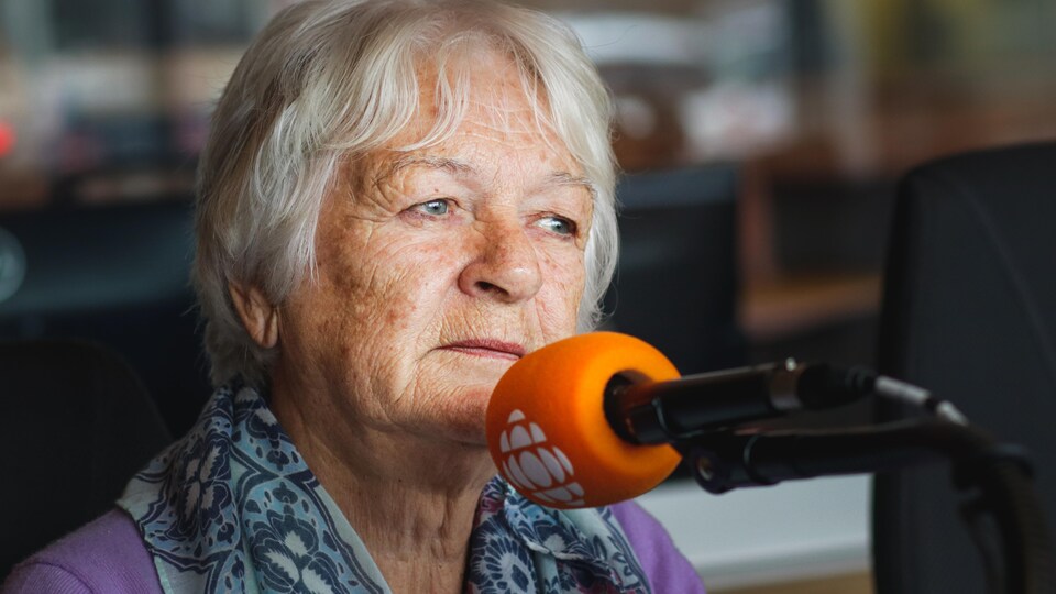 Une femme qui parle à un micro.
