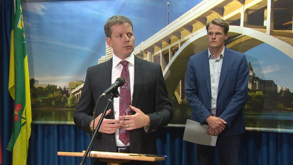 Jeff Jorgenson parle au micro avec à côté de lui le maire Charlie Clark lors d'une conférence de presse.