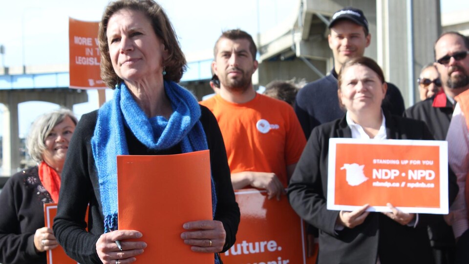 Jennifer McKenzie et des candidats et partisans tenant des affiches orange.