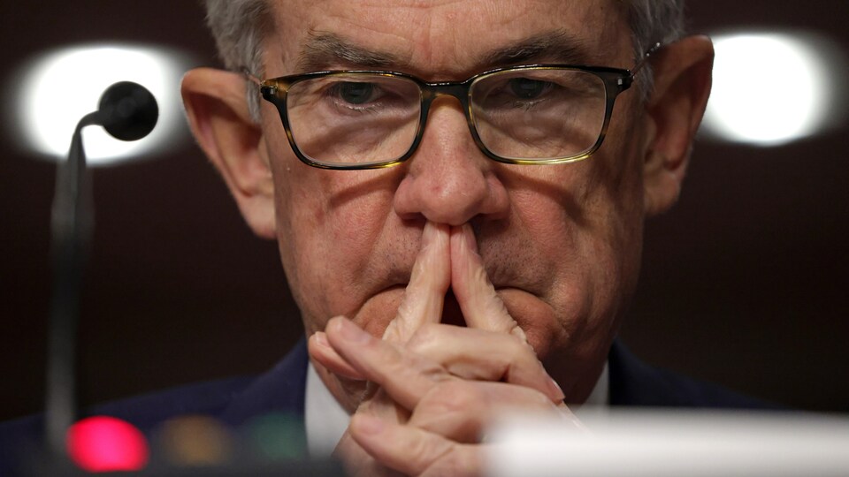 Jerome Powell, les index joints devant sa bouche, l'air pensif.