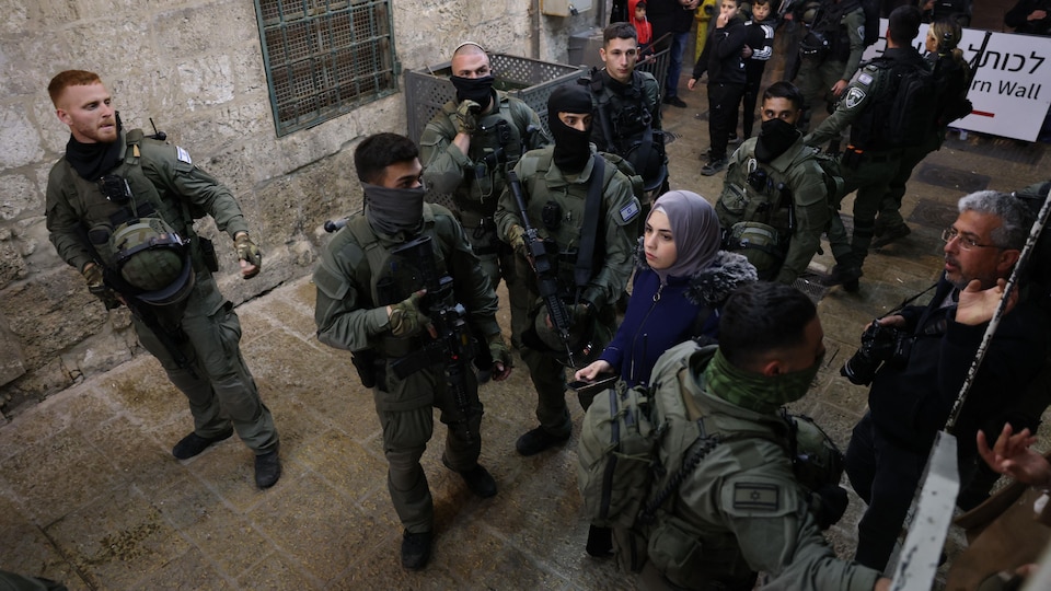 Des policers entourant un groupe de civils