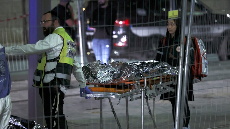 Des secouristes israéliens transportant un corps sur une civière.