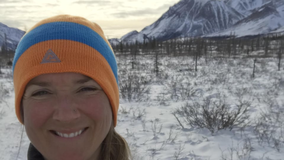 Jessie Thomson-Gladish qui a terminé un marathon de sept jours prend un égoportrait devant une chaîne de montagnes.