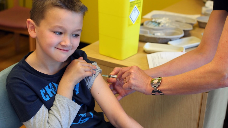 Un garçon reçoit le triple vaccin.