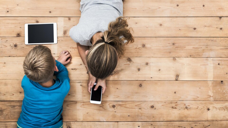 Des jeunes utilisent un téléphone intelligent et une tablette.