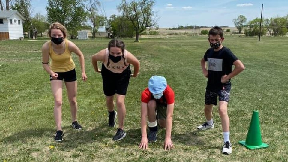 Quatre jeunes se prépare à courir en plein-air.