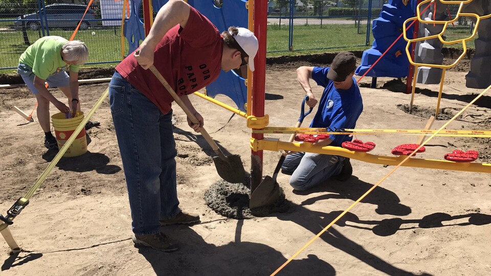 Deux hommes installent une structure récréative.