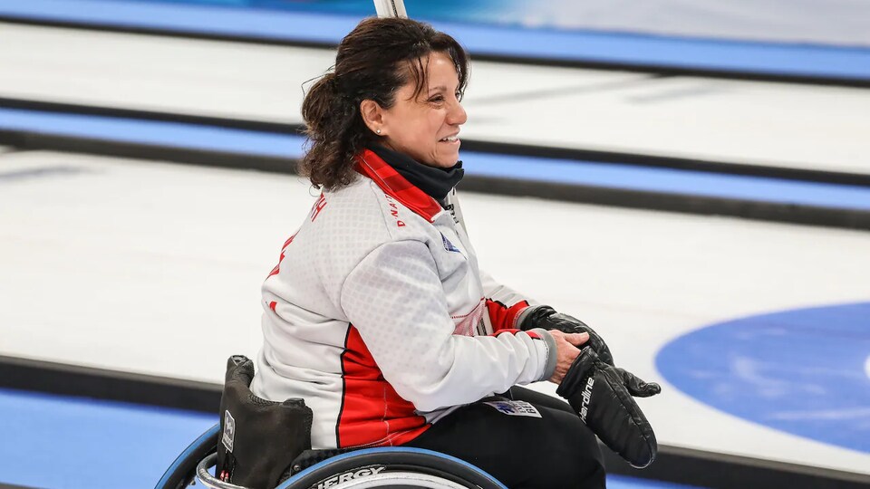 Une personne en chaise roulante sur une piste de curling.