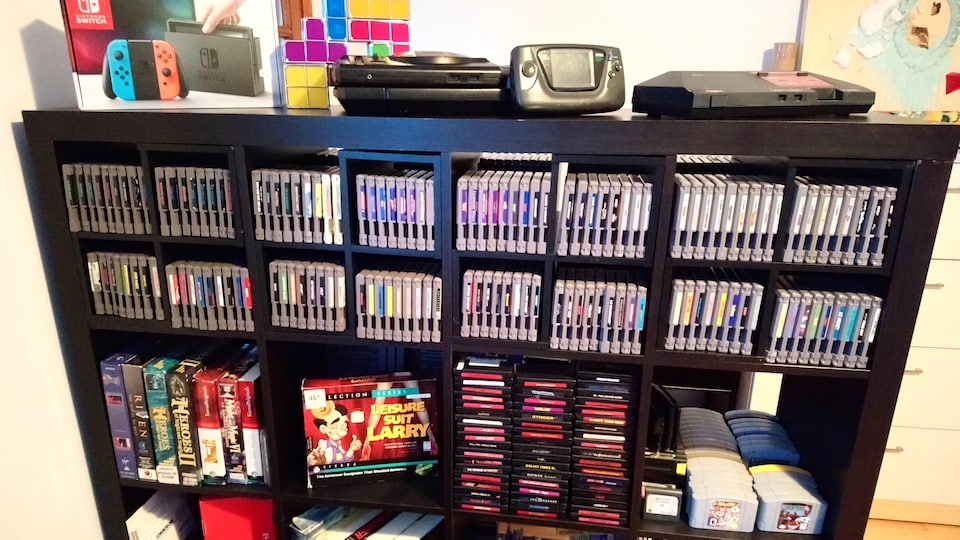 Une bibliothèque pleine de cartouches de jeux vidéo rétro de diverses consoles.