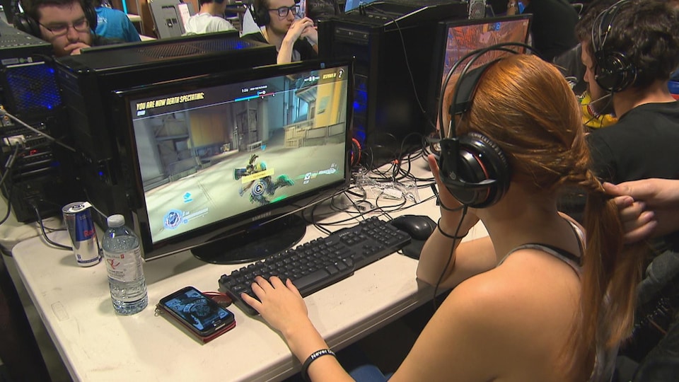 Une adolescente joue à un jeu vidéo sur un ordinateur.