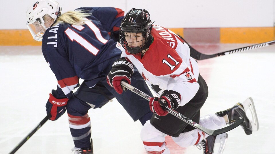 La joueuse de hockey Jillian Saulnier sur la glace près d'une joueuse des États-Unis.