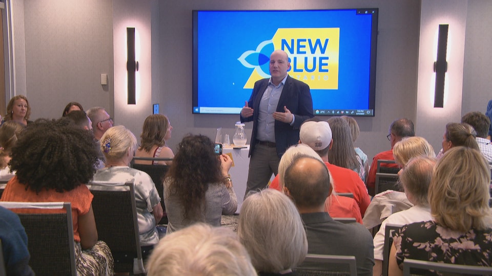 Le chef du Nouveau Parti bleu, Jim Karahalios, discute avec des partisans.