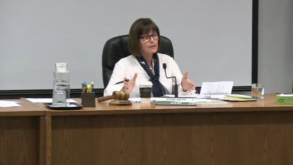 La mairesse de Nipissing Ouest assise à une table pendant une réunion du conseil municipal.