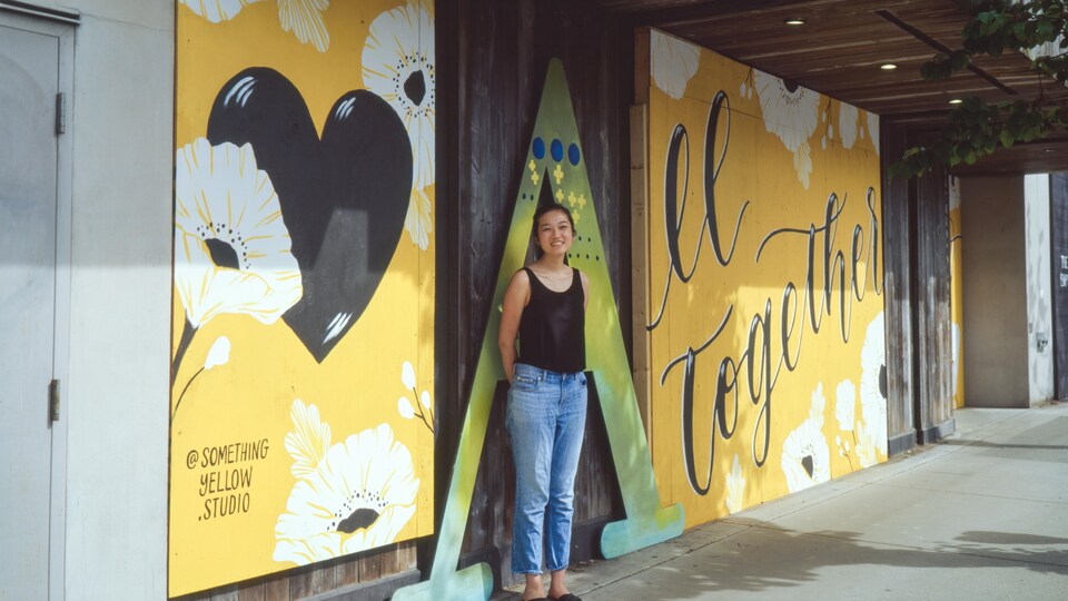 Jocelyn Wong devant la peinture murale qu'elle a peinte.