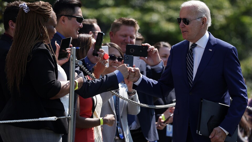 Le président Joe Biden marche en saluant la foule.