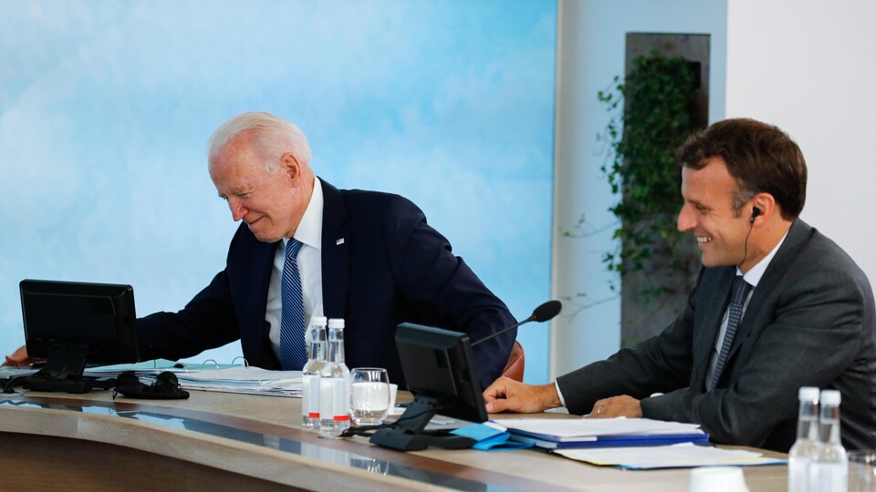 Joe Biden et Emmanuel Macron sont assis et semblent rire.