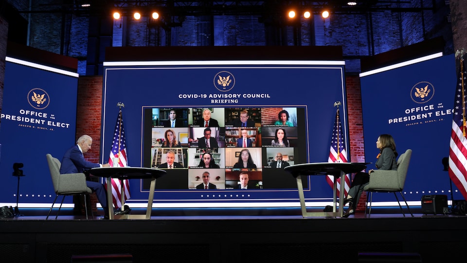Joe Biden et Kamala Harris sont assis chacun à un bureau et assistent à une réunion virtuelle.