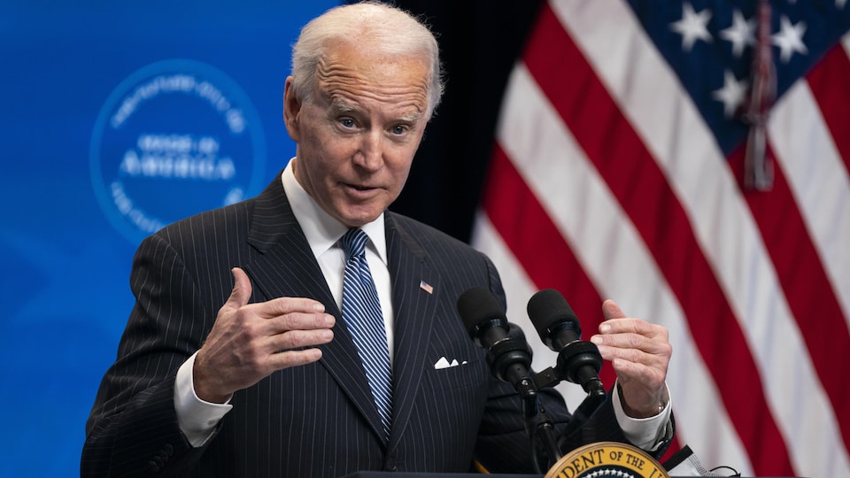 Joe Biden devant un lutrin, près d'un drapeau des États-Unis.