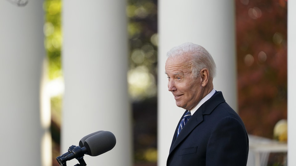 Le président Biden sourit aux gens rassemblés devant lui dans le jardin de la Maison-Blanche.