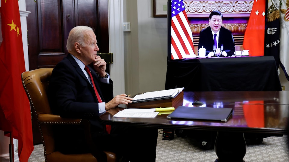 Le président américain Joe Biden et l'image du président chinois Xi Jinping sur un écran de télévision
