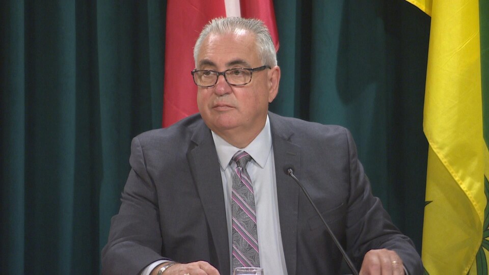 Joe Hargrave, assis, donne une conférence de presse.