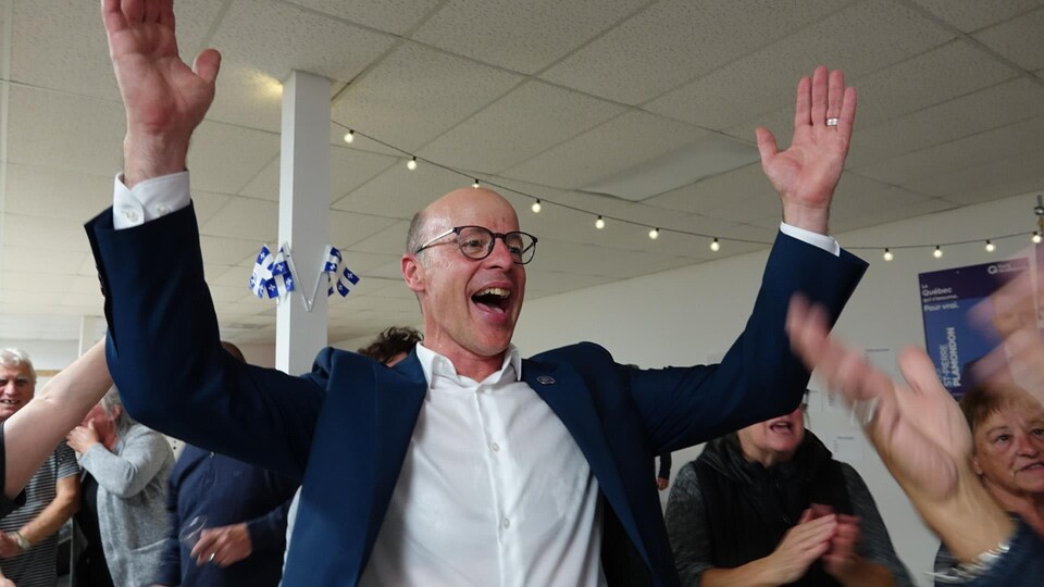 Joël Arseneau, les bras en l'air, fête sa victoire dans la circonscription des Îles-de-la-Madeleine.