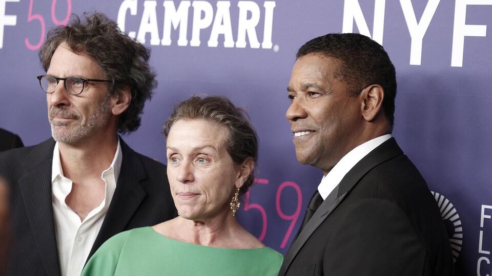 Deux hommes et une femme posent pour les caméras lors de la première d'un film à New York.