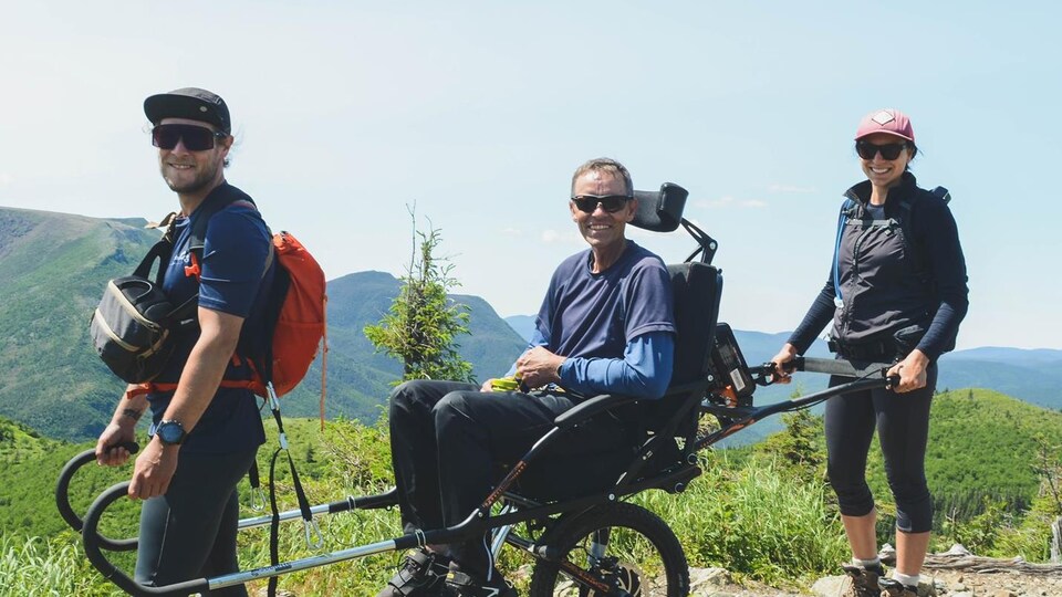 Patrick Beckrich est transporté en Joëlette par deux accompagnateurs.