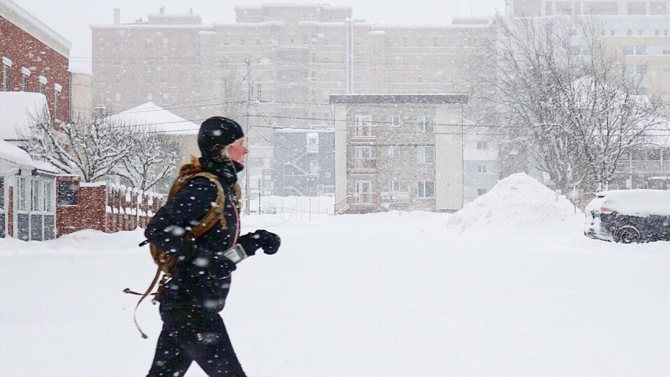 Une personne fait du jogging au centre-ville de Rimouski, dans la tempête.