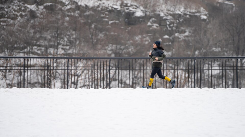 Une femme court dans le parc Major à Ottawa en hiver.