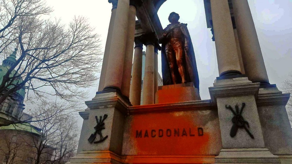 Le nom de MacDonald est maculé de peinture orange, tout comme la statue.
