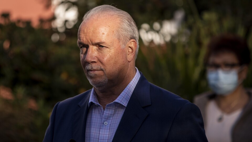 John Horgan regarde vers la droite dans un rayon de soleil.
