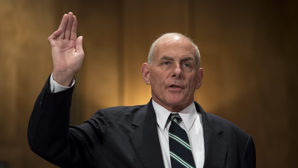 Le nouveau chef de cabinet de la Maison-Blanche, John Kelly, prête serment, la main droite dans les airs.