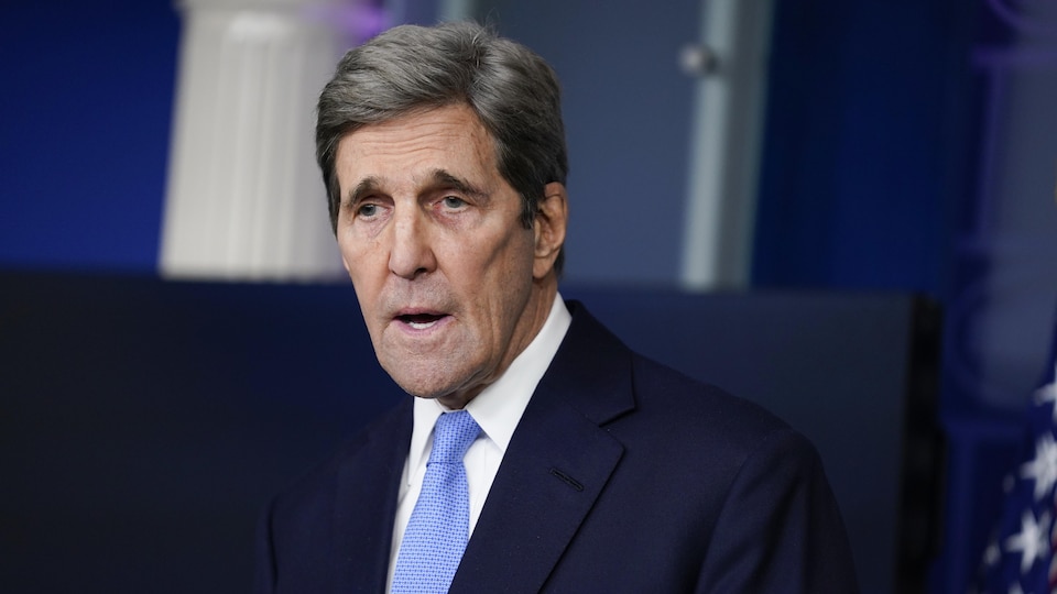 John Kerry se tient debout la bouche ouverte. 