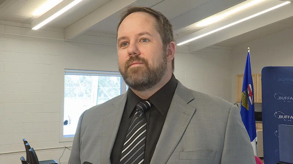 John Molberg, le chef du Parti Buffalo de l'Alberta, est debout dans une pièce.