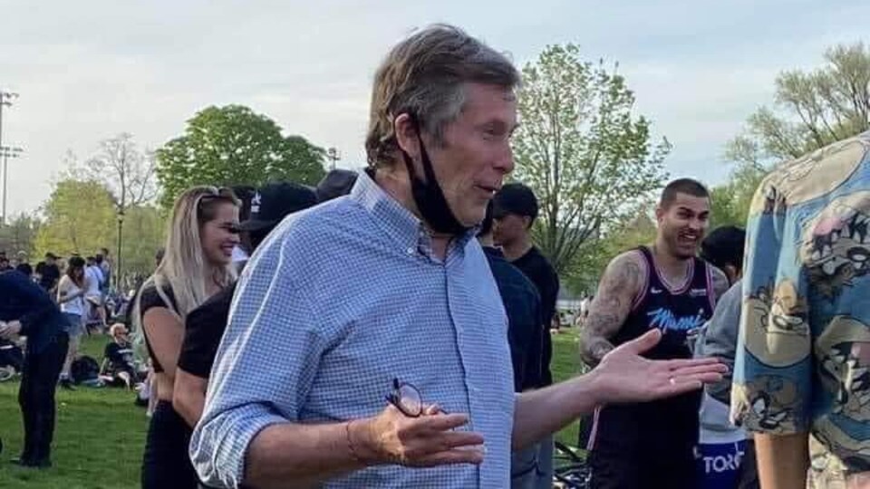 John Tory a abaissé son masque alors qu'il parle à quelqu'un.