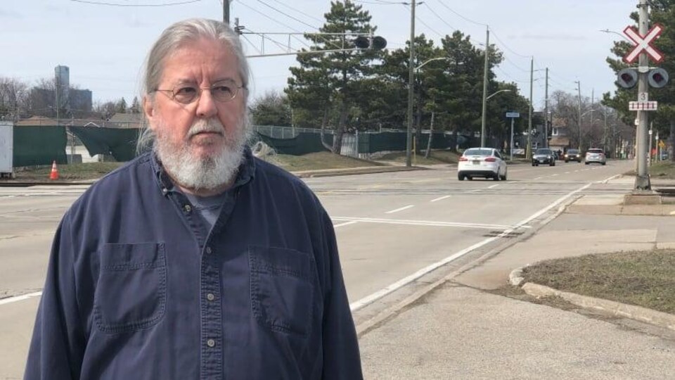 John West se tient près du passage à niveau de l'ETR.